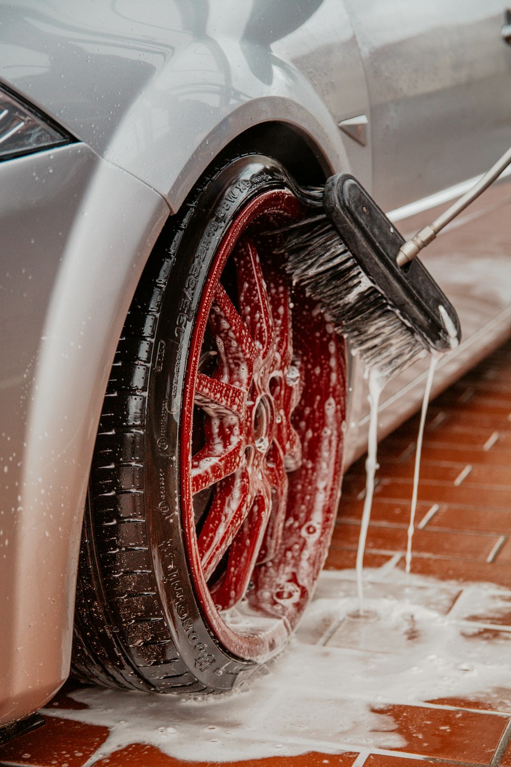 Alloy wheel being washed with water and cleaner