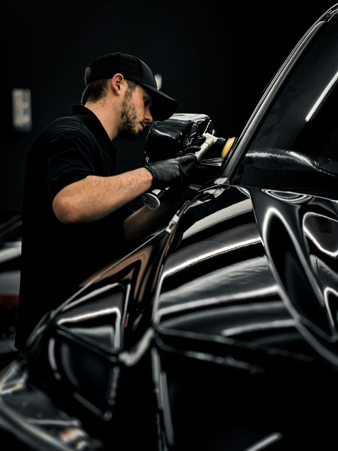 Technician applying wax to car paint by hand