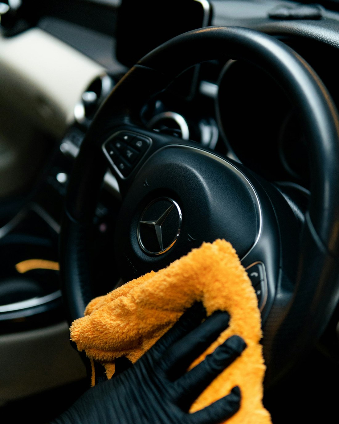 Detailer wiping a car interior with a microfibre cloth