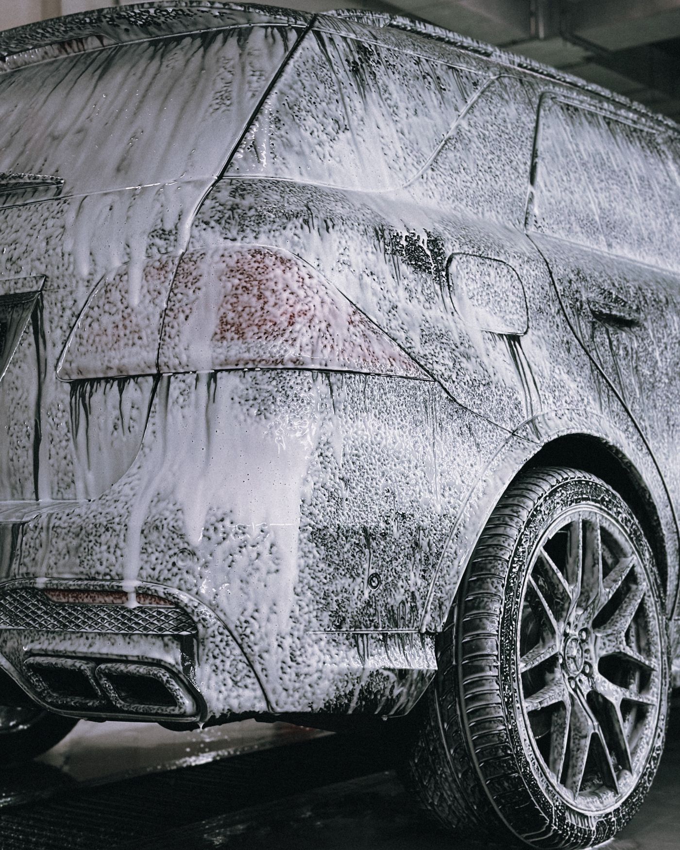 Premium SUV covered in thick snow foam during a pre-wash